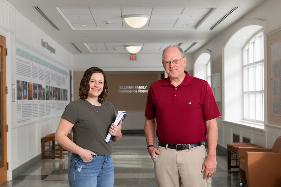 Mackenzie Mangos standing with sport management professor Rodney Paul.