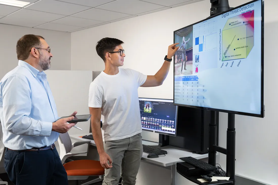 Professor and student looking at data on a screen.