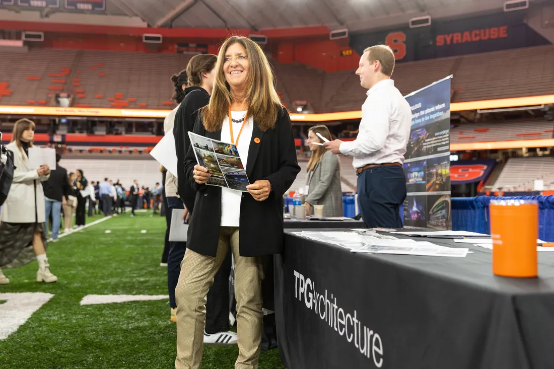 Bette Samuel standing and smiling in front of her booth.