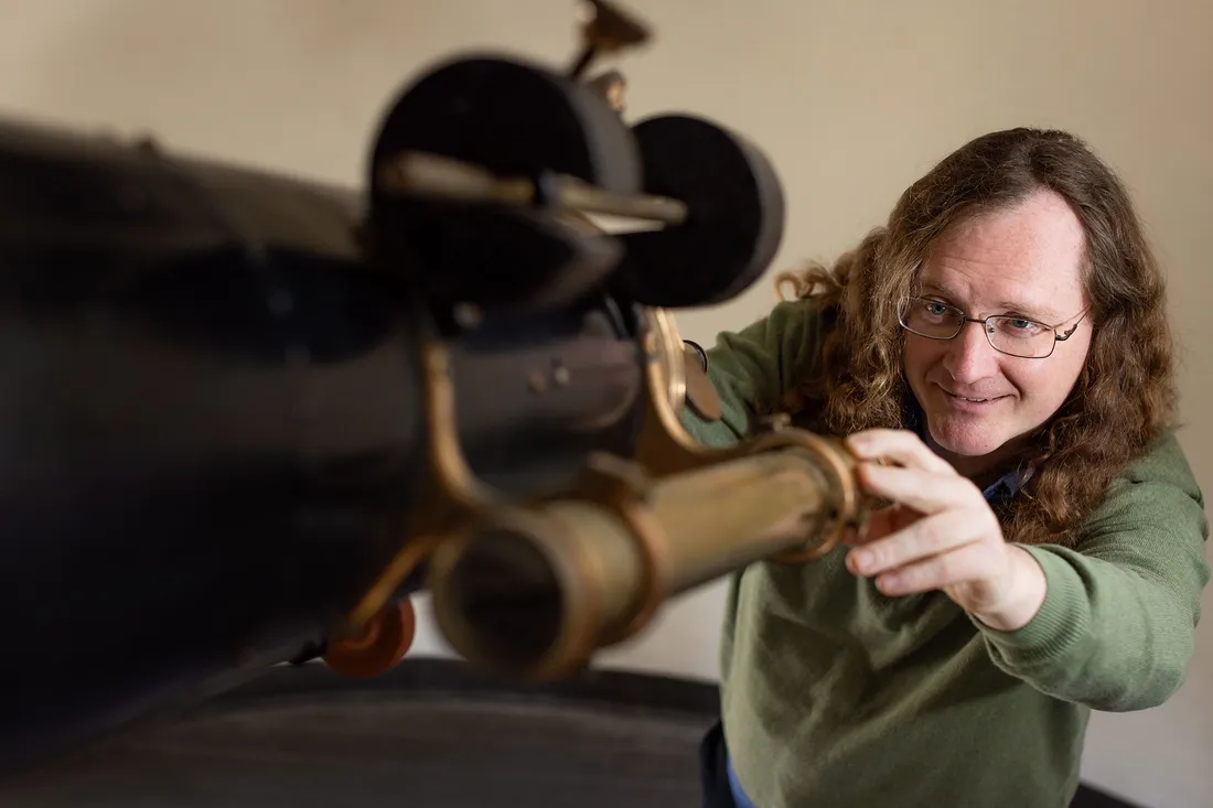 A person looking through a Telescope.