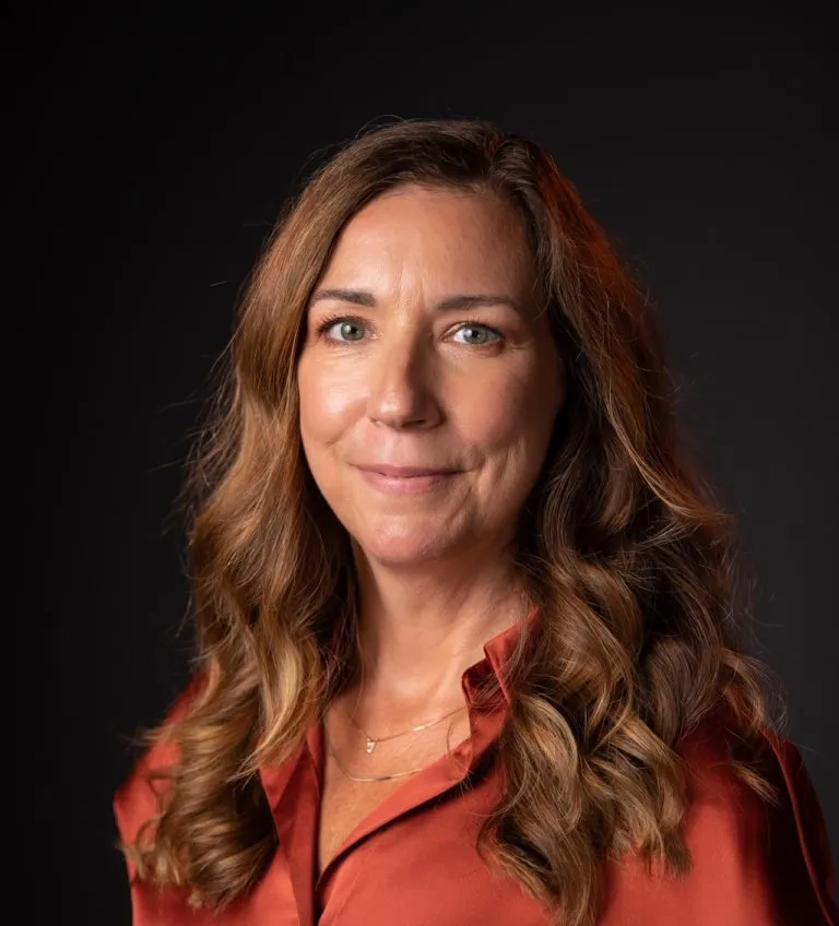 Becky O'Hara smiling in a red button up.