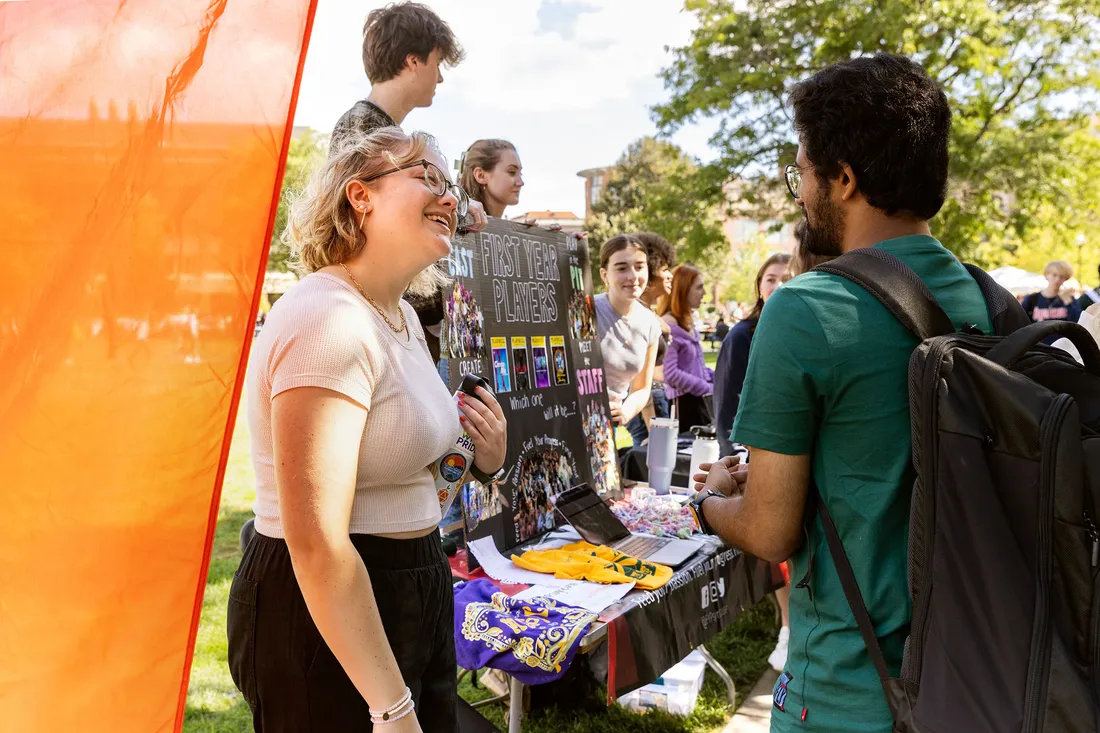 Students at table talking at involvement fair.