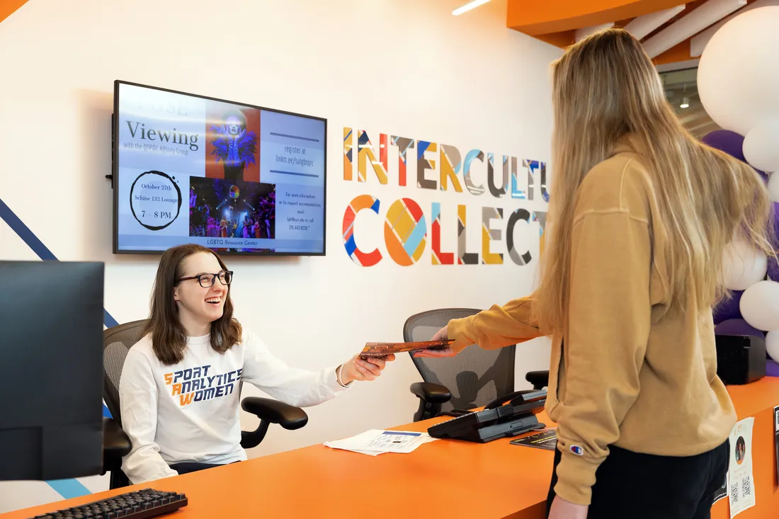 Alison Gilmore handing paper to student.