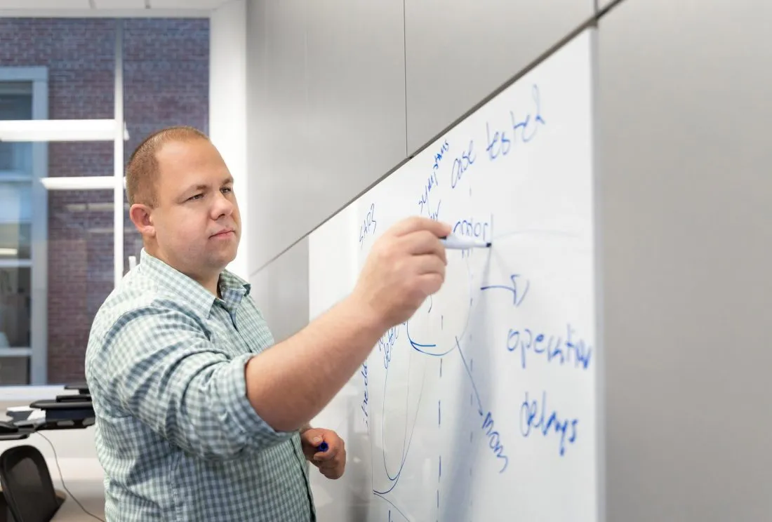 Professor writing on a white board.