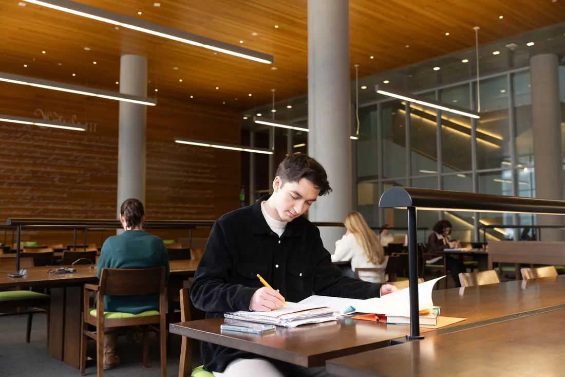 Student sitting and studying inside of Dineen Hall.