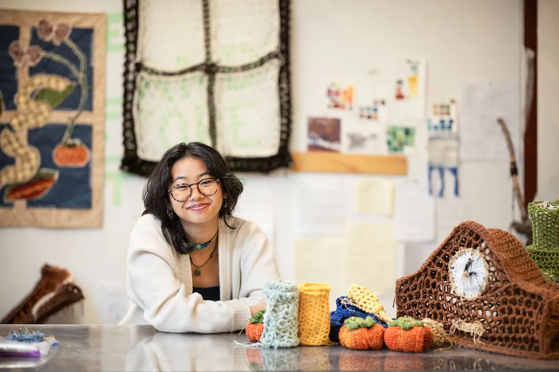 Student smiling with her crocheted artwork