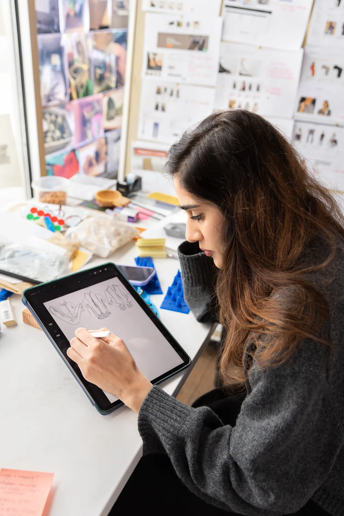 Photo of female student drawing digital sketches on iPad tablet.