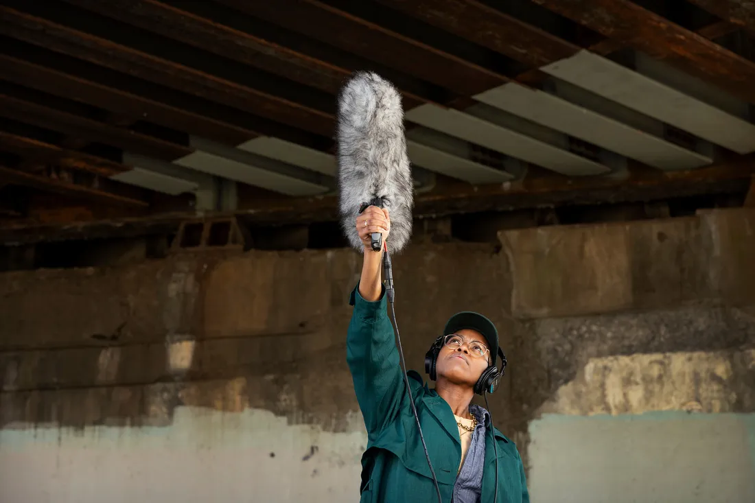 Person holding sound boom up towards a bridge