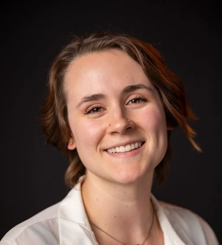 Karley Harmon smiling in a white button up top.