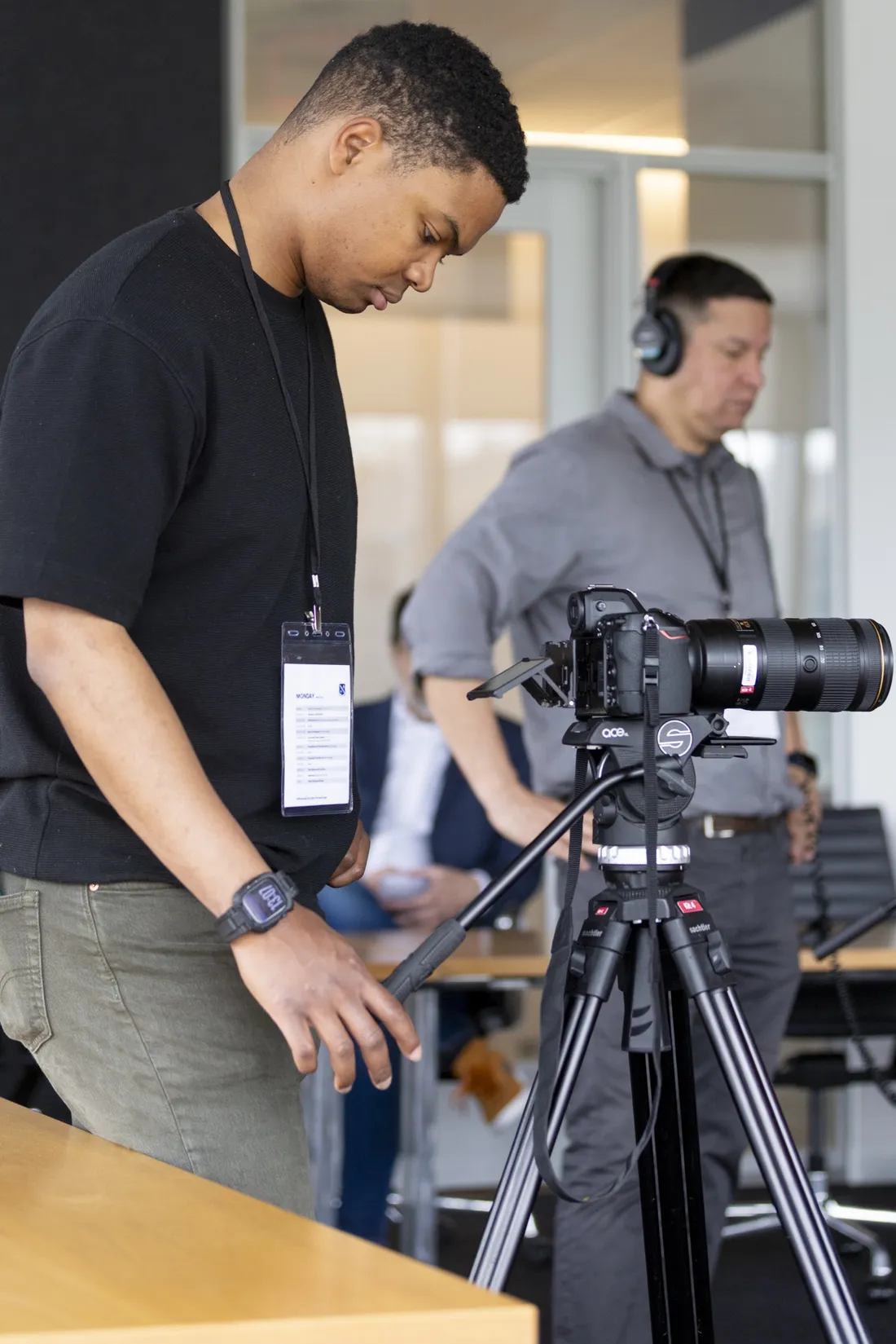 Sgt. Jamie Robinson standing behind a camera filming.