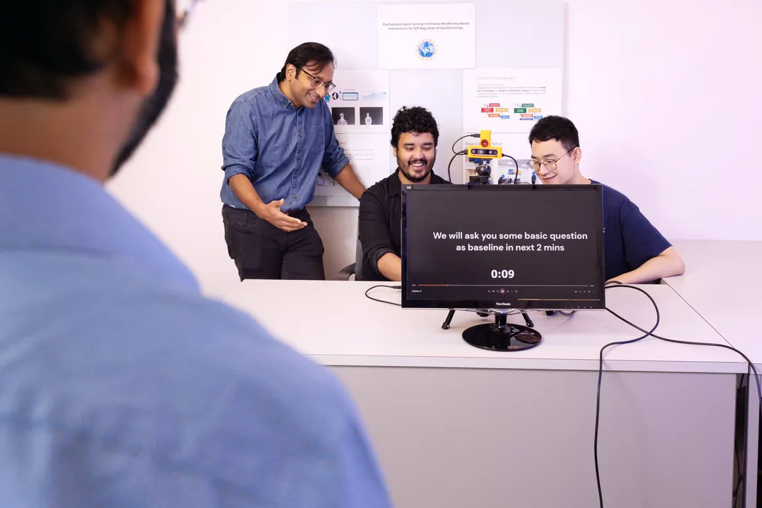 Professor Asif Salekin (left) and doctoral candidates Harshit Sharma and Yi Xiao looking at computer.