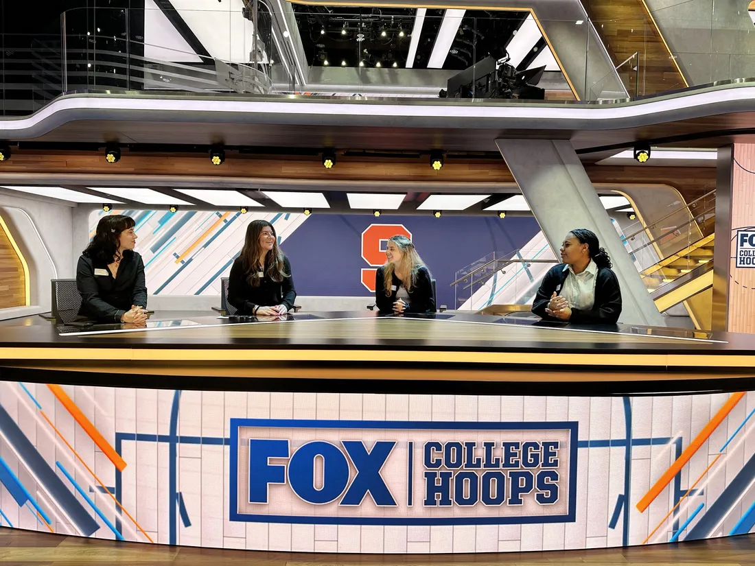 Students and professionals sitting at the Fox College Hoops desk inside the Fox Sports building in Los Angeles.