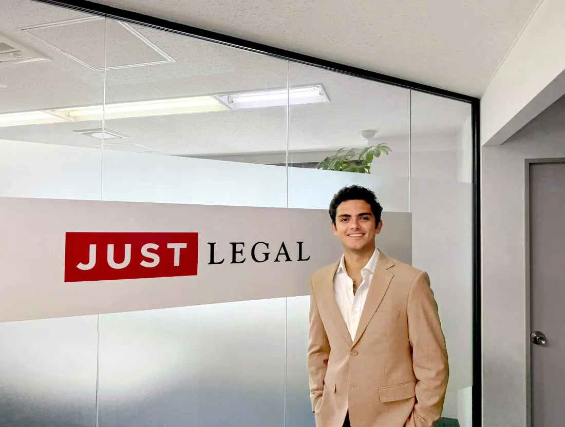 Person standing in front of sign in an office.