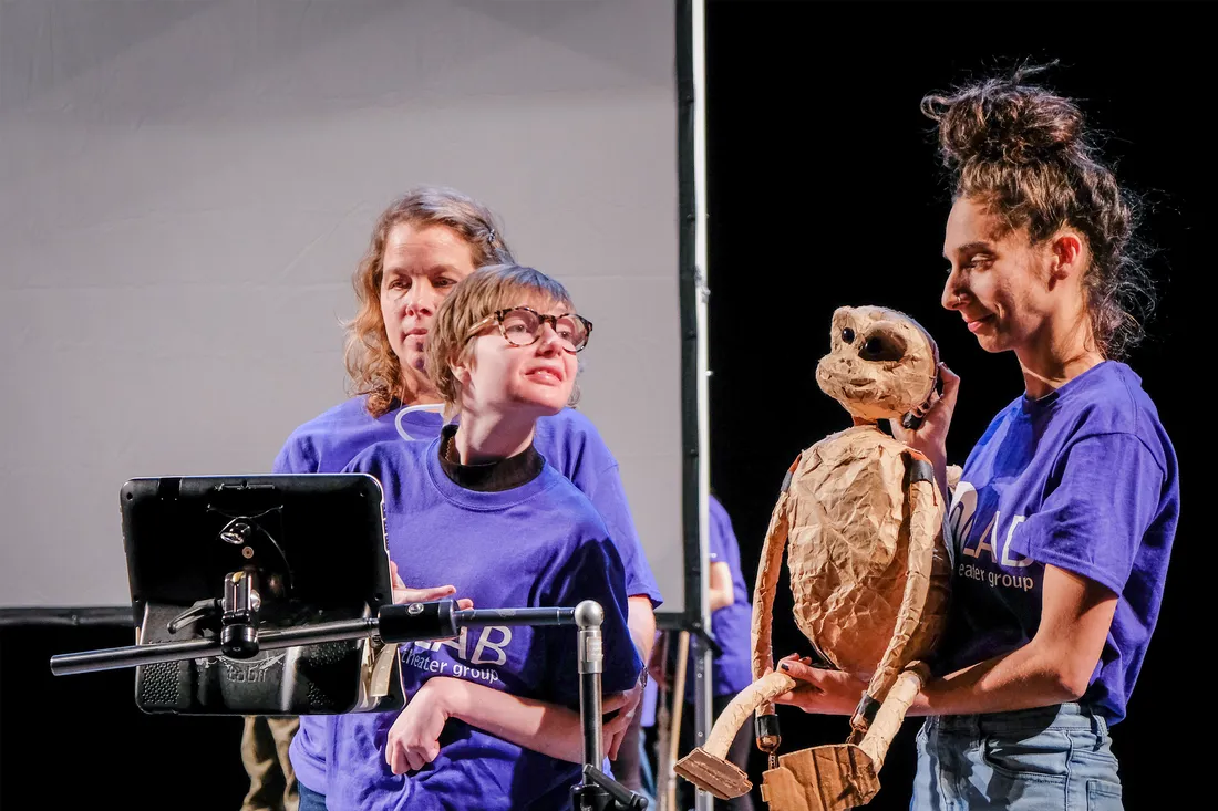 Arielle Lever holding a prop and performing on stage with other members of CO/LAB.