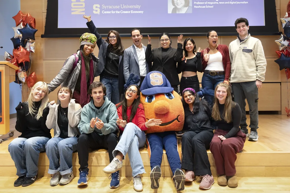 Carmella Boykin '21 posing alongside students and Otto the Orange following her panel at the Center for the Creator Economy event.