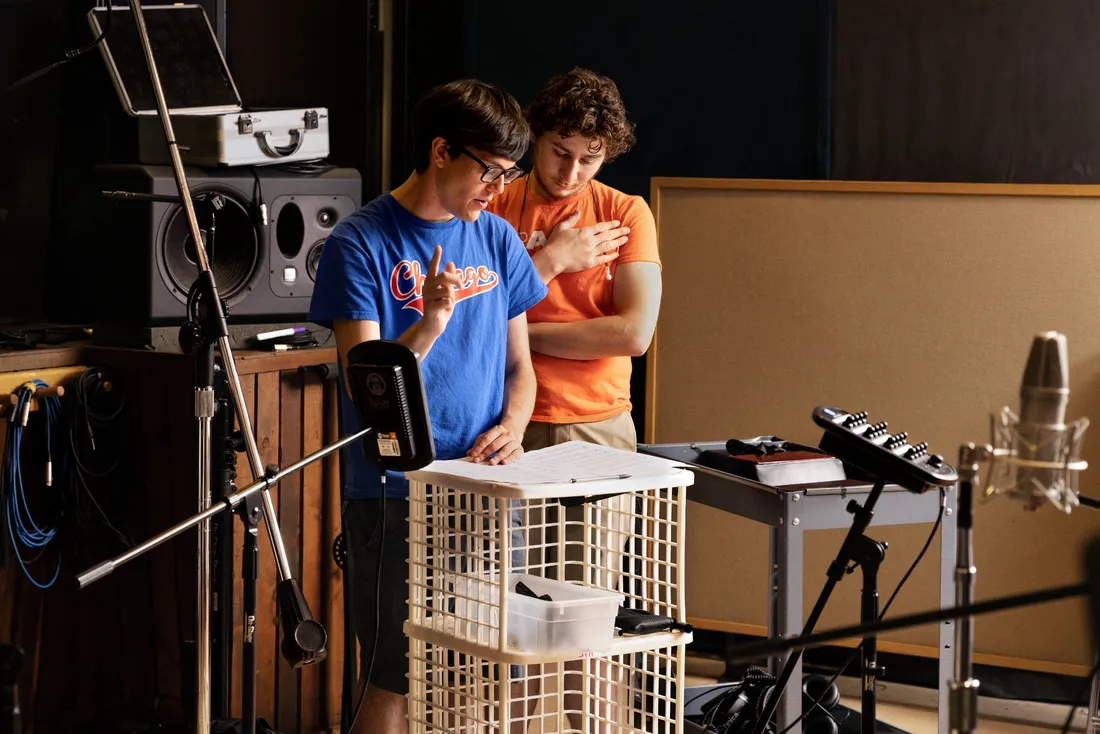 Jeremy Shinder and another student standing and reading a script.