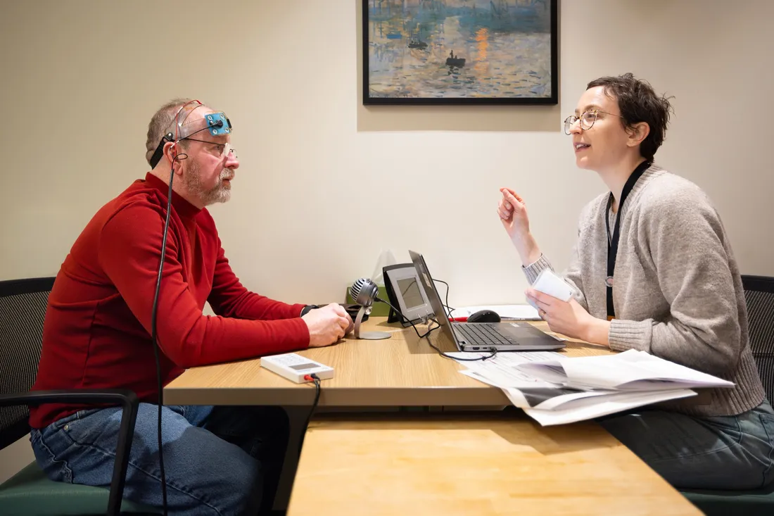 Syracuse University Aphasia Lab worker Jenny Fortin speaks to a patient undergoing a clinical trial.