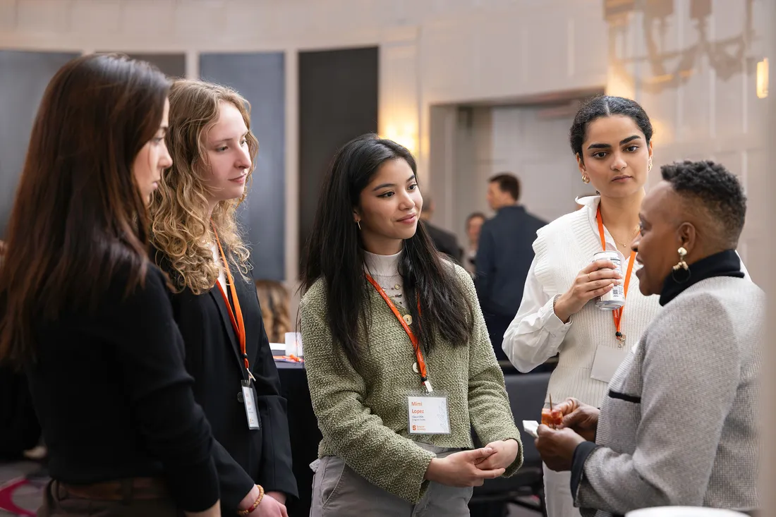 Students talking to someone at an alumni networking event.