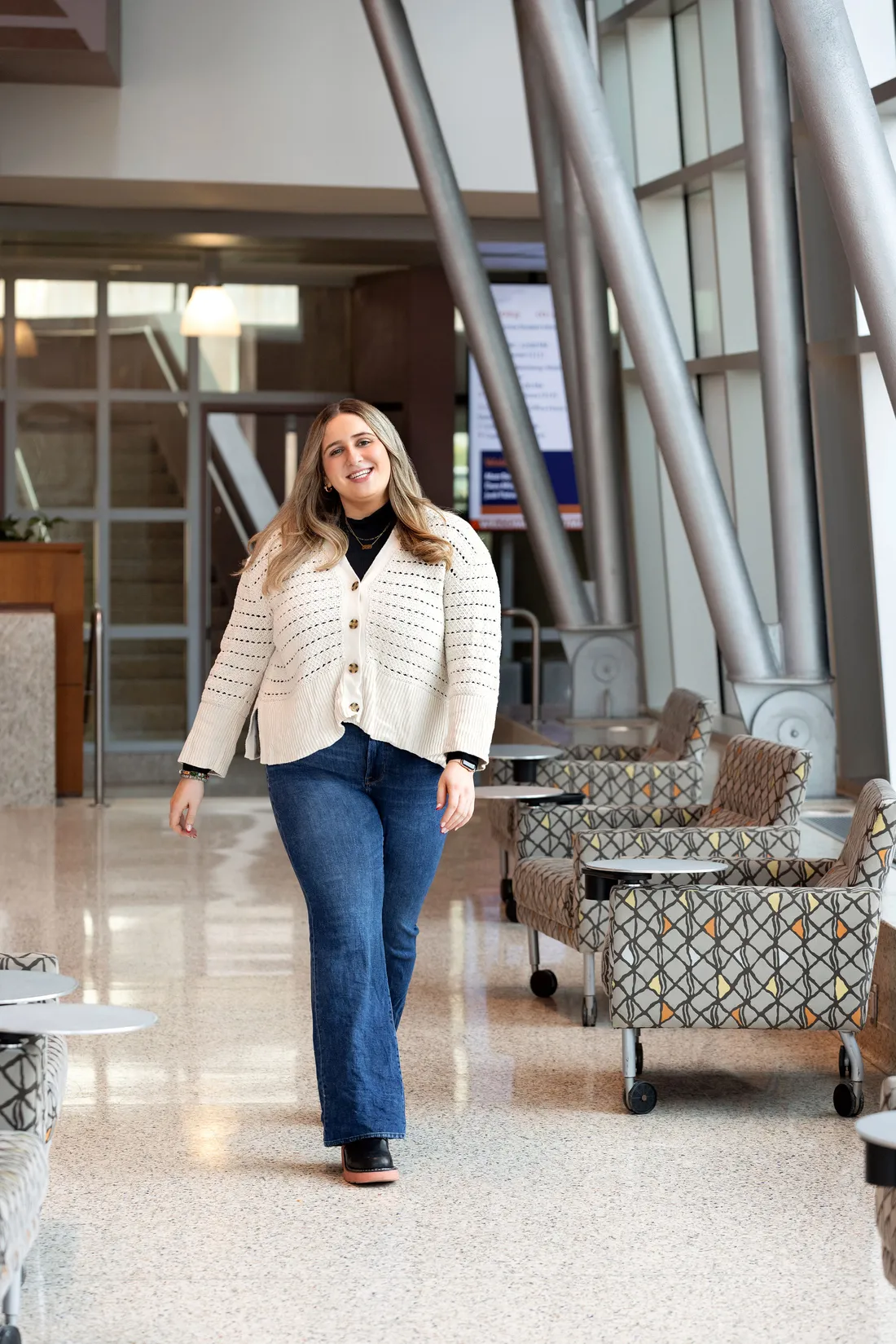 Isabella Simon walking in a building on syracuse University's campus.