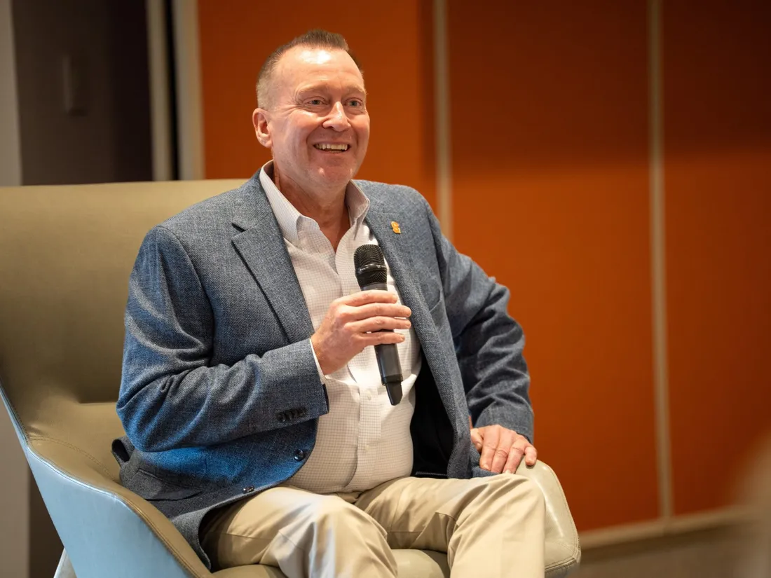 Chancellor Mike Haynie sitting in a chair holding a microphone.