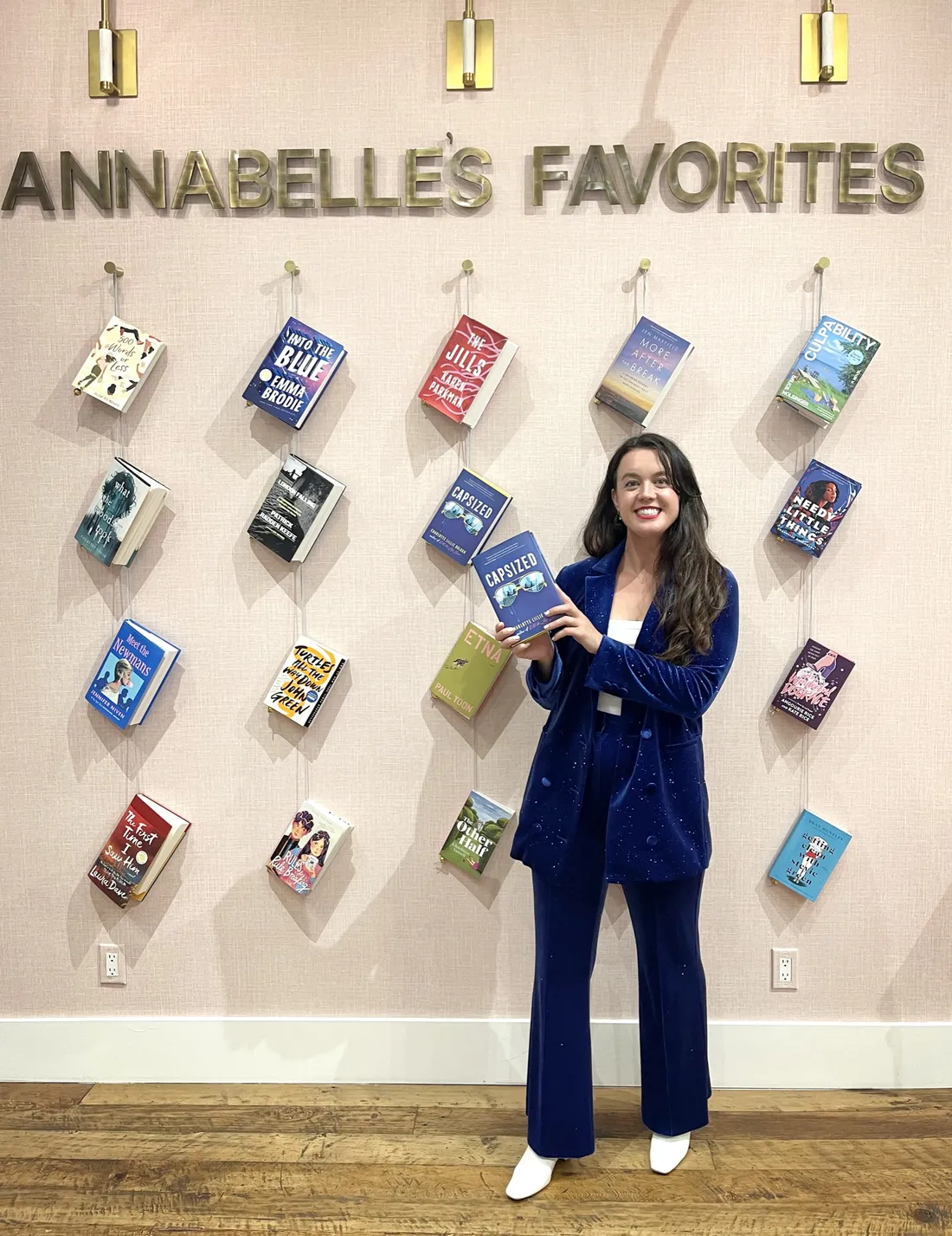 Charlotte Lillie Balogh ’17 standing in a bookstore holding up a book she authored.