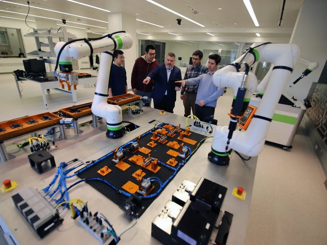 A group of students listening to a professor talk inside Alex Jone's laboratory.