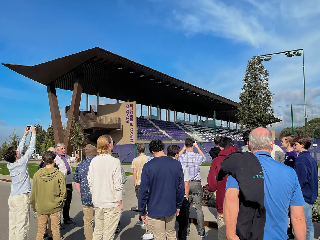 A group of people outside a soccer stadium.