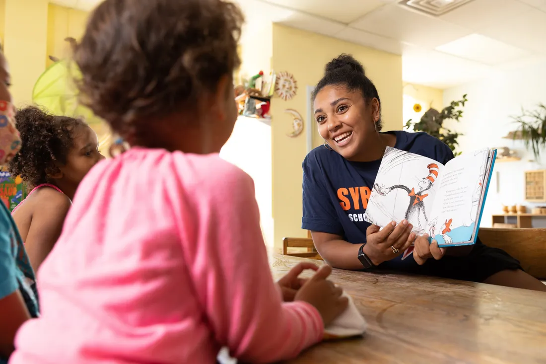 Education student reading to children.