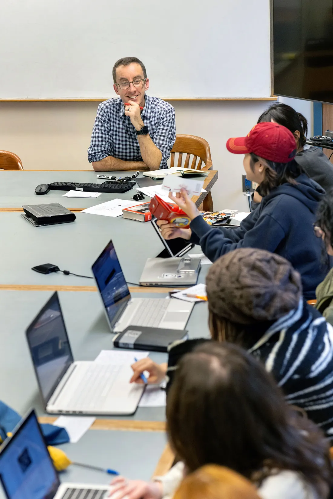 A person talking with others at a desk.