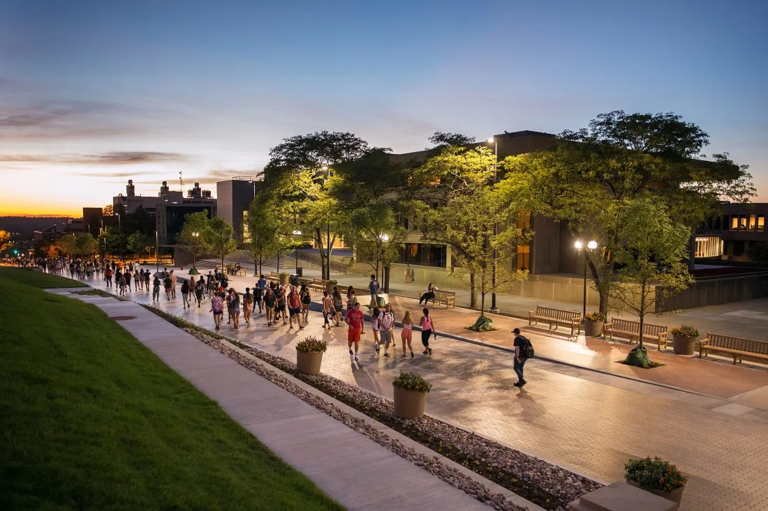 Students walk along the Einhorn Family Walk at dusk.