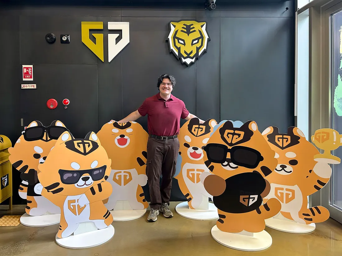Person standing among paper cut outs of cartoon characters.