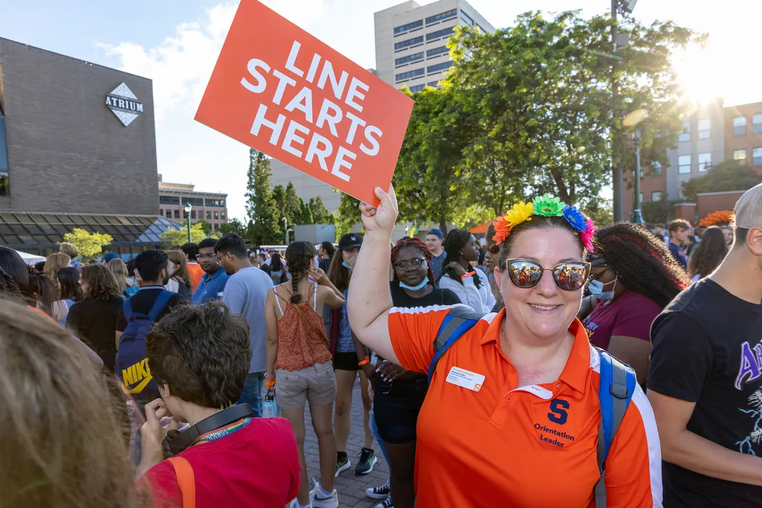 Female student holds up sign during Syracuse University welcome week.