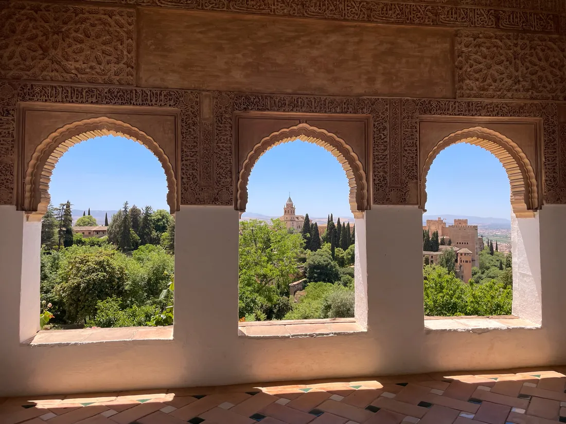 Spanish countryside viewed through a series of three arches.