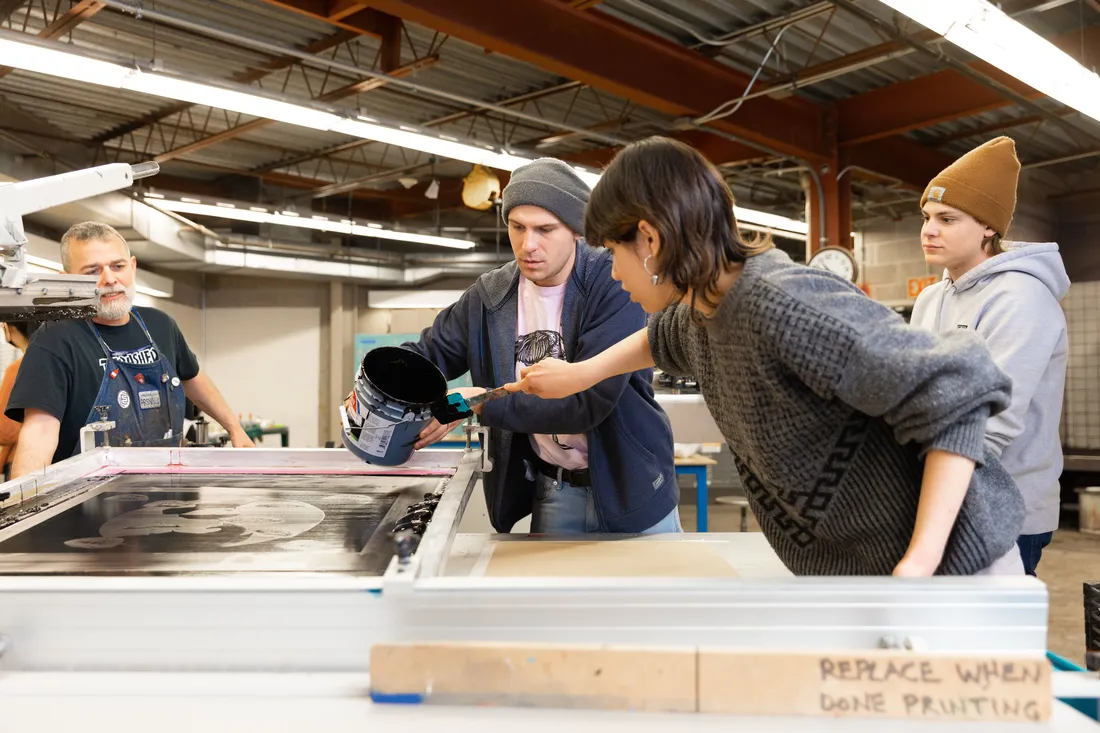 Screen printing students working on project with professor.