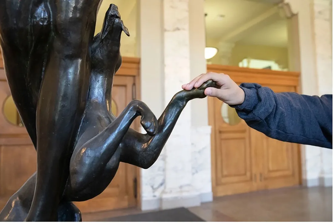 Student touching a statues paw.