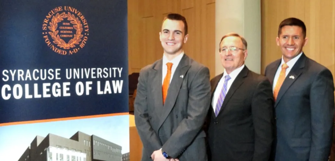 People smiling for photo with John A. DeFrancisco in the College of Law.