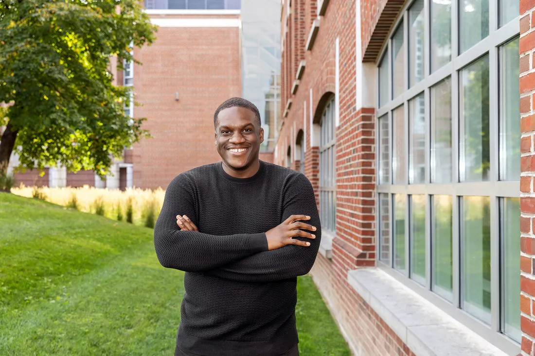 Portrait of Jamal Salmon standing outside with his arms crossed, smiling.