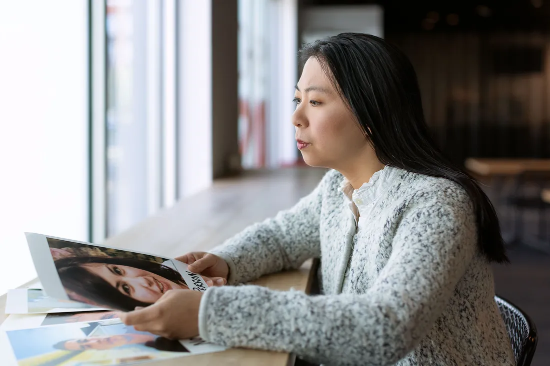Person sitting and looking at a picture of a fake person avatar.