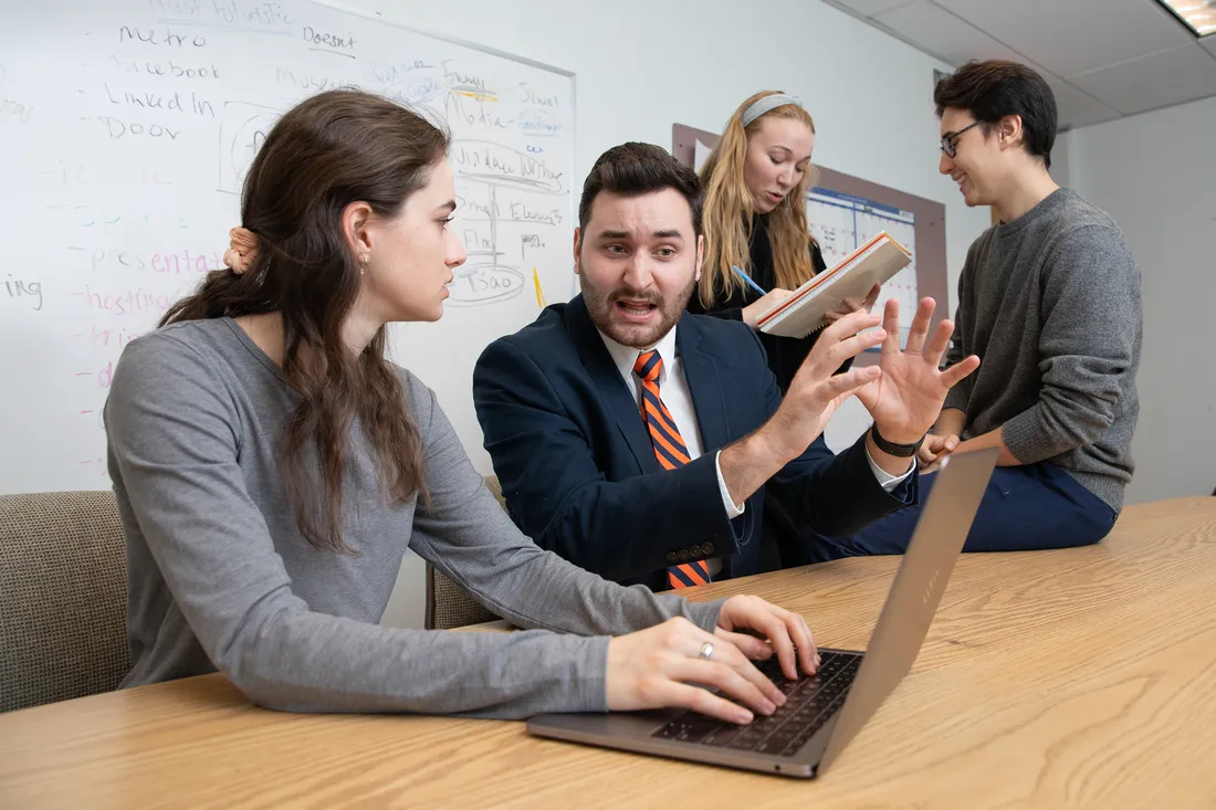 Man and woman in business casual looking at a laptop.