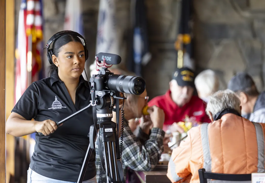 Arlene Carrara standing behind a camera filming a project for Clear Path for Veterans.