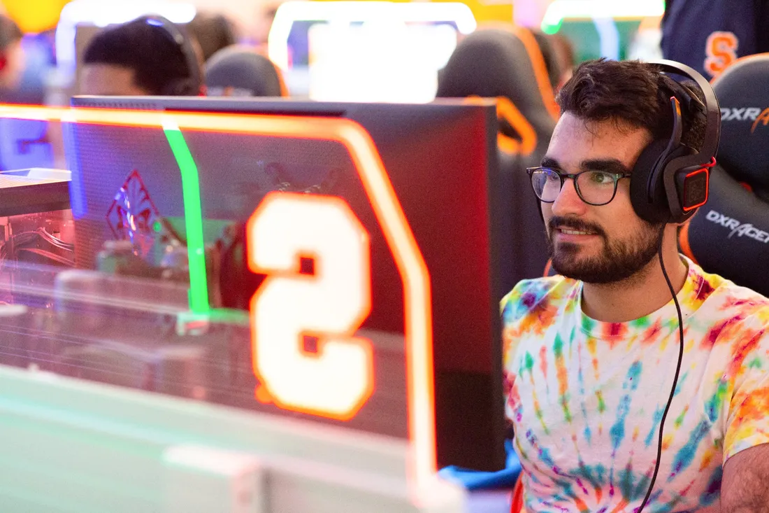 Man with headphones on sitting in front of a computer