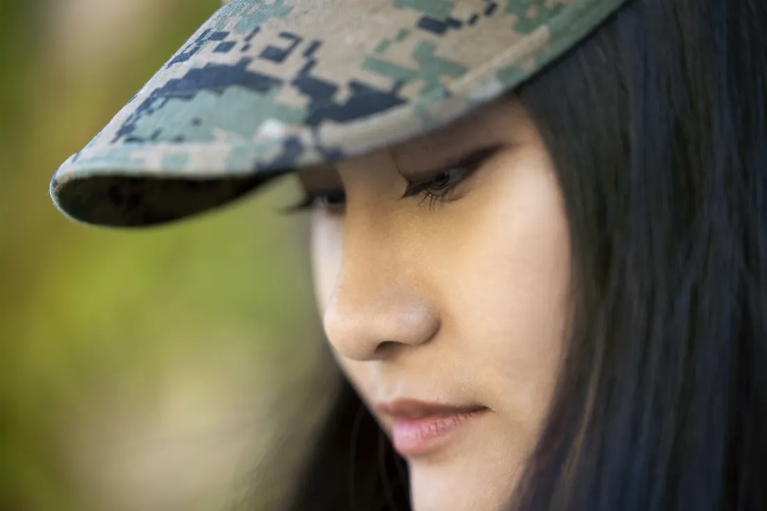 Amy Tran ’27 looking down while wearing a camouflage hat.