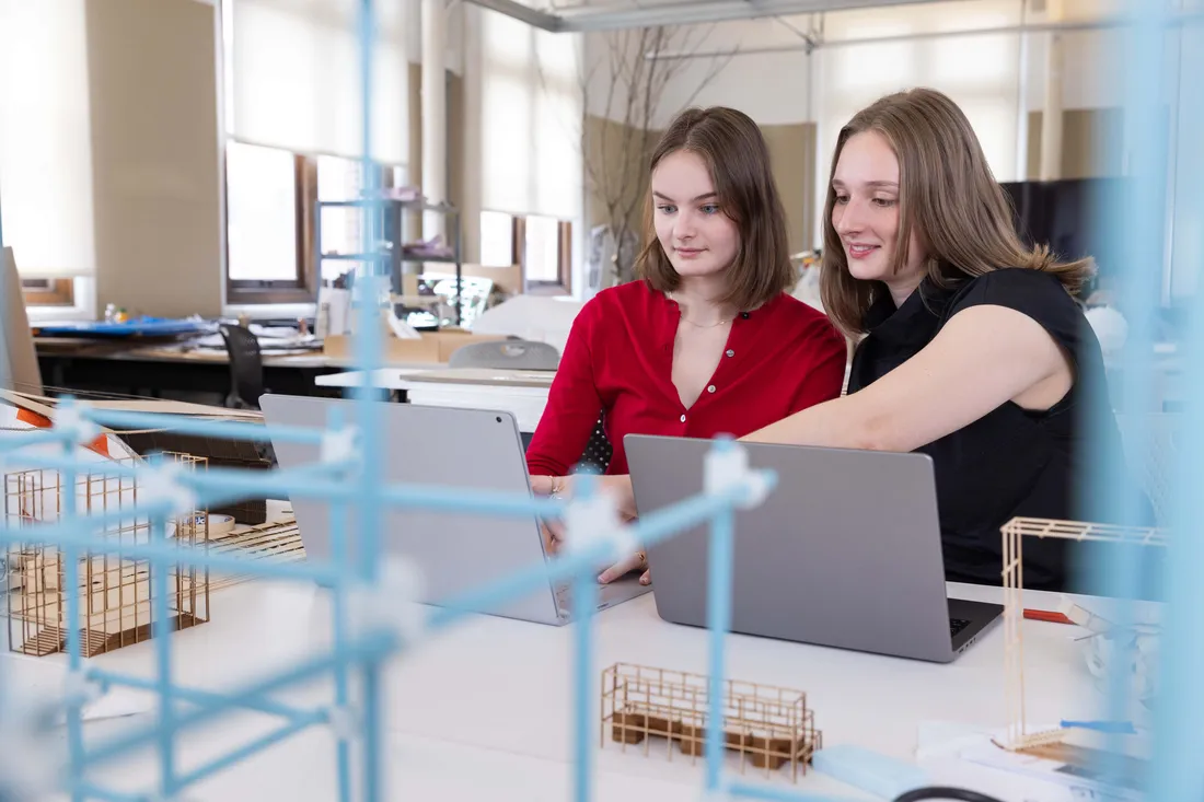 Two students working on an architectural model project.