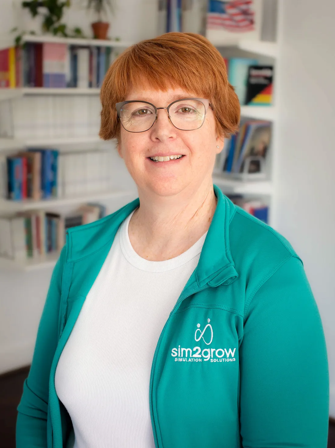 Headshot of person with a bookshelf in the background.