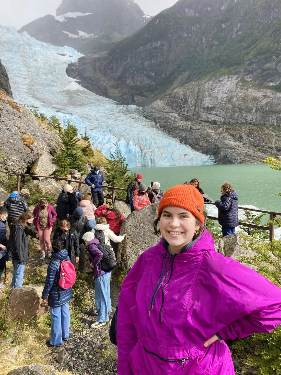Sophie Clinton posses in front of scenic overlook of glacier carving out valley.