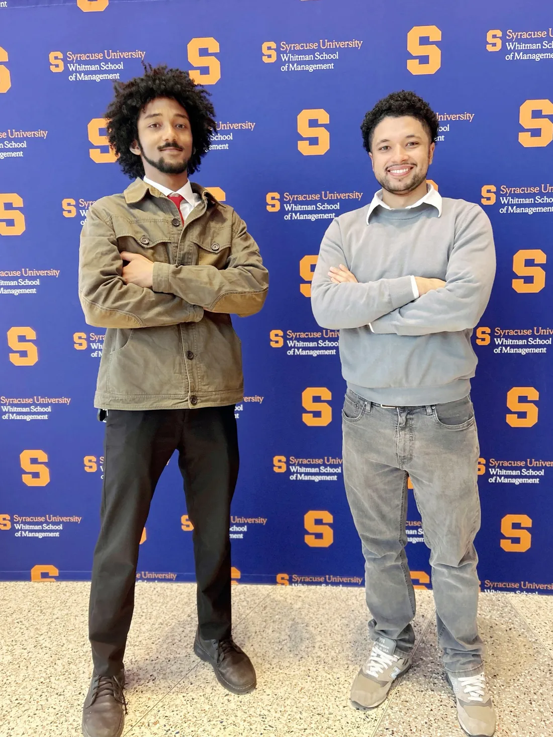 Alumni Jon Carter and Kristian Nunez standing inside of the Martin J. Whitman School of Management.