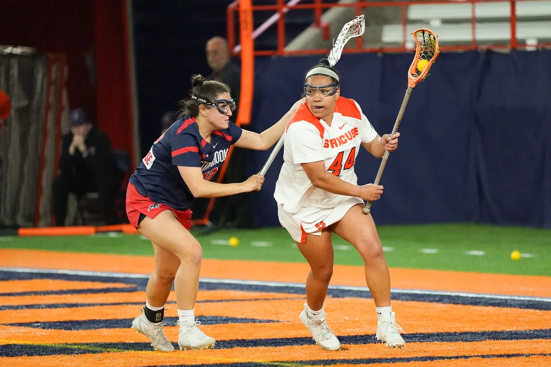 Female students playing lacrosse.