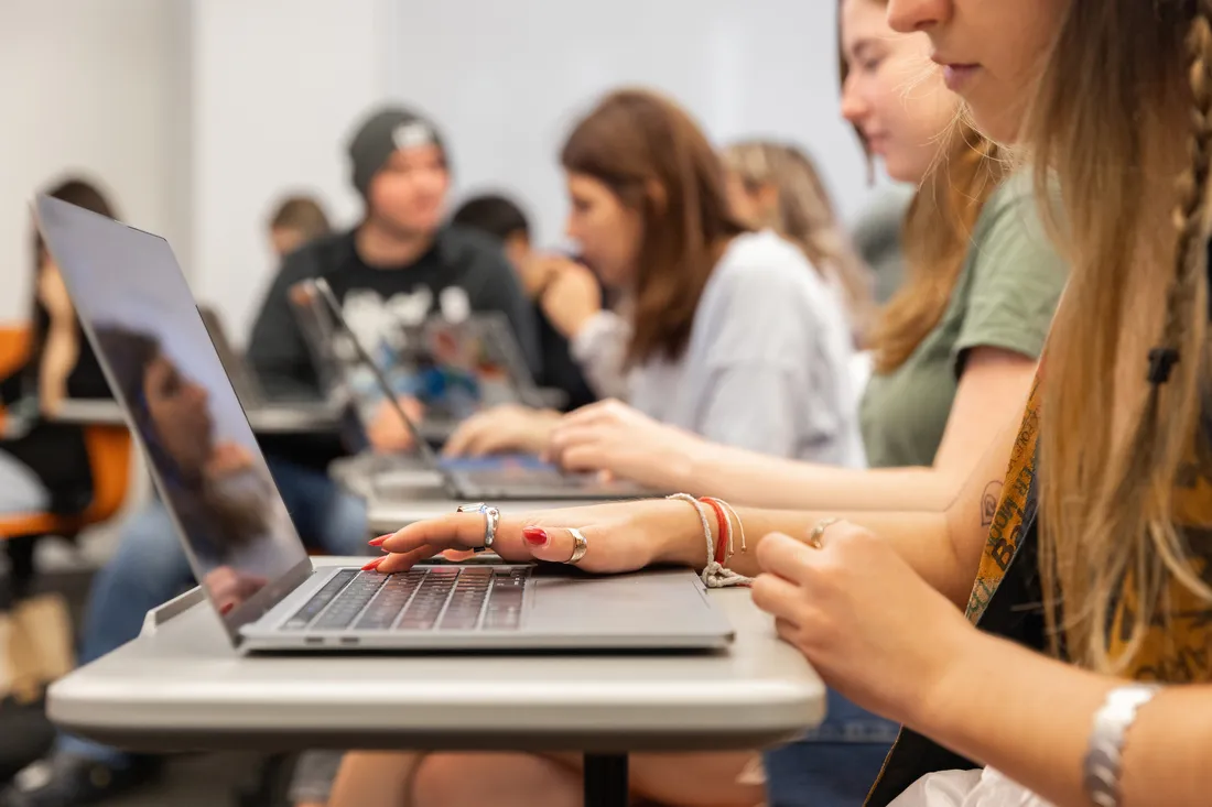 Professor talking with students in an office.