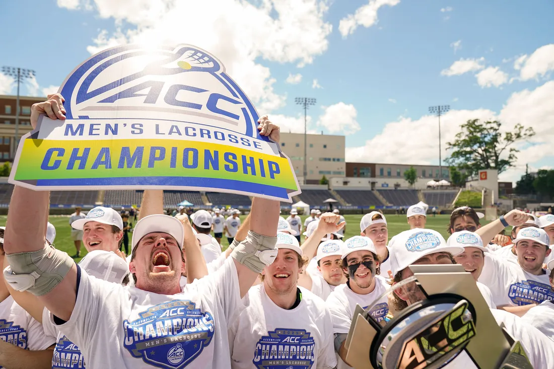 Mens Lacrosse team holding up the title.