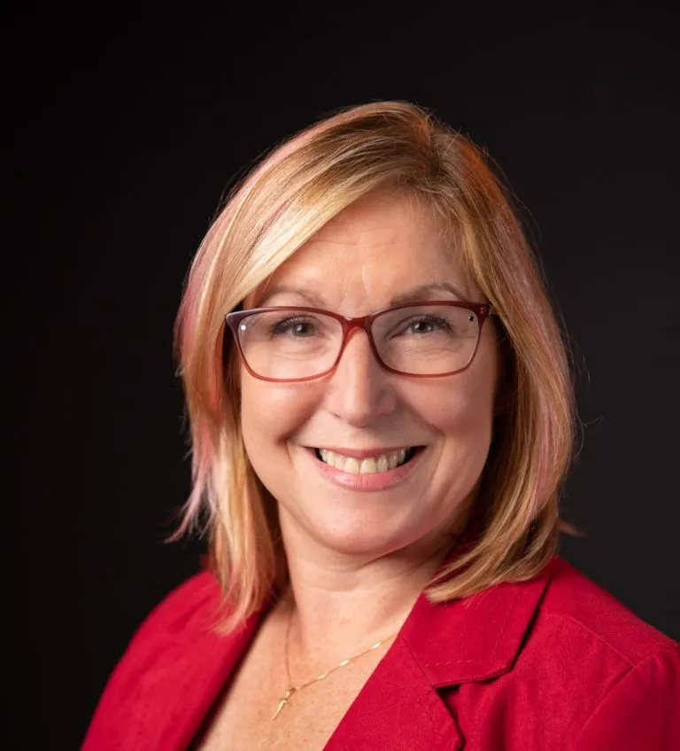 Amy Holl smiling in a red blazer.